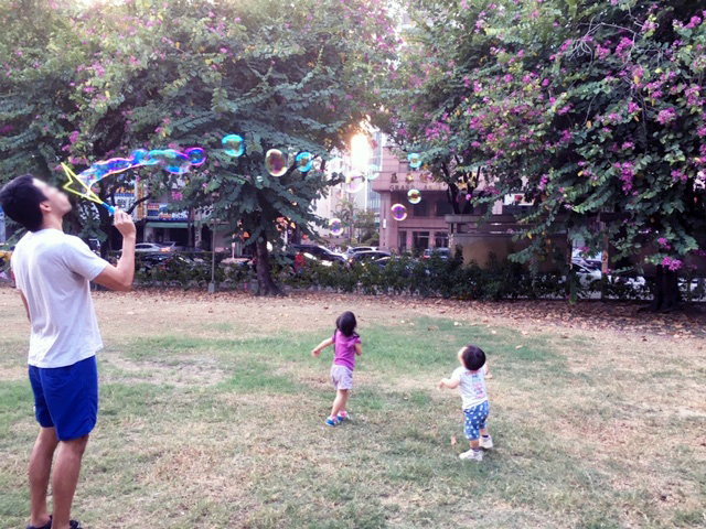 シャボン玉で遊ぶ子供の写真。